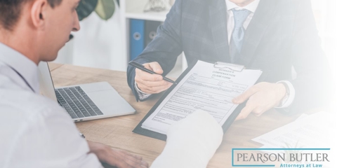 man with broken arm looking over forms with workers' comp. attorney